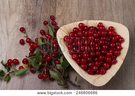 Fresh Red Cherries In A Wooden Plate On A Wooden Table. Wooden Plate On A Wooden Background. Next To