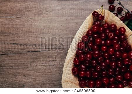 Fresh Red Cherries In A Wooden Plate On A Wooden Table. Wooden Plate On A Wooden Background. Next To