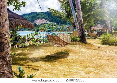 Tropical Beach. A Hammock Between Two Palm Trees On The Beach. Concept Of Rest. Beautiful Beach.