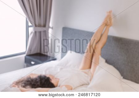 Blurred Photo - Modern Bedroom, Large Bed, White Linens, Young Woman With Black Hair In White T-shir