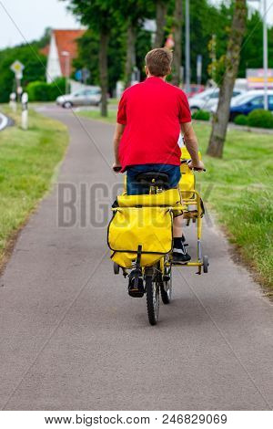 Postman Riding His Cargo Bike Carrying Out Mail In Neighborhood