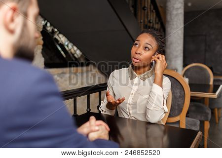 A Man In A Blue Jacket Is Taking An Exclusive Interview From A Pretty Afro-american Woman In A White