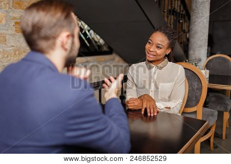 A Man In A Blue Jacket Is Taking An Exclusive Interview From A Pretty Afro-american Woman In A White