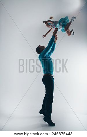 Family Portrait On The Floor On White Background. A Man Lifted A Girl Up. The Trust Business Partner
