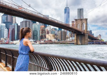 New York city NYC summer travel tourist woman enjoying view of Manhattan skyline from Brooklyn park living a happy lifestyle walking during USA vacation. Female Asian tourist in her 20s.