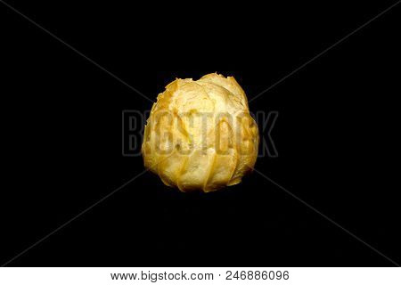 A Single Profiterole Isolated On The Black Background.