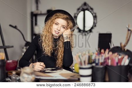 Portrait Of Beautiful Artist Painter Girl Sittiing At The Table Full Of Colorful Pencils Drawing Ske