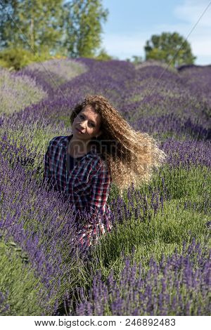 Ostrow, Poland - June 6, 2018: Beautiful  Woman With Long Curly Hair In The Middle Of A Lavender Fie