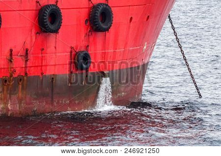 Rusty Red Ship On Hull With Water Splash Out From Ship.