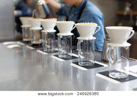 The Proccess Of Hand Dripping Coffee In The Coffee Shop. Barista On The Background.