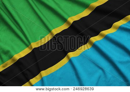 Tanzania Flag  Is Depicted On A Sports Cloth Fabric With Many Folds. Sport Team Waving Banner