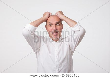Elderly Man In Surprise Grabs His Head. He Got Promotion At Work Or Good News From Somebody