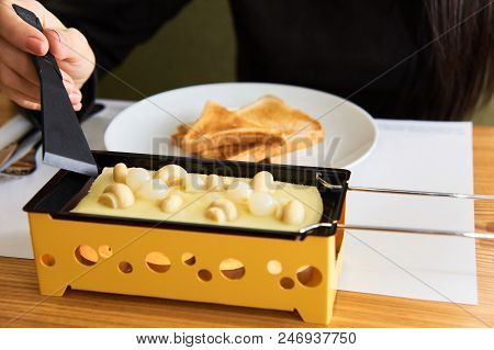 Swiss Food. Cheese Raclette With Mushrooms On Coupelles - Special Small Skillet For A Raclette
