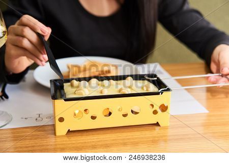 Swiss Food. Cheese Raclette With Mushrooms On Coupelles - Special Small Skillet For A Raclette