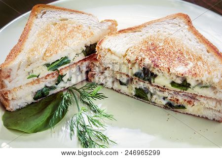 Hot Sandwich With Spinach, Cheese And Herbs, Lying On A Plate