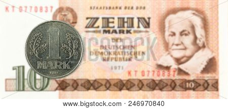1 Mark Coin Against Historic 10 East German Mark Bank Note
