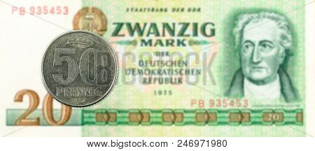 50 Pfennig Coin Against Historic 20 East German Mark Bank Note