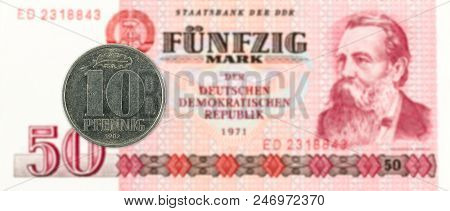 10 Pfennig Coin Against Historic 50 East German Mark Bank Note