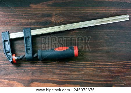 One Clamp On Work With Wood Lying On A Wooden Board