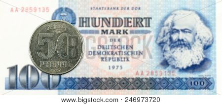 50 Pfennig Coin Against Historic 100 East German Mark Bank Note