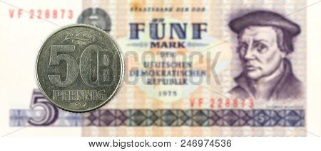 50 Pfennig Coin Against Historic 5 East German Mark Bank Note