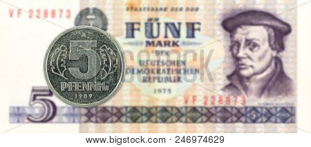 5 Pfennig Coin Against Historic 5 East German Mark Bank Note