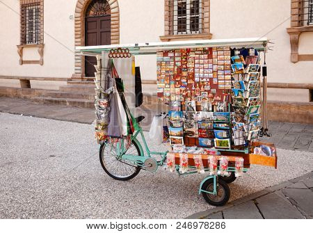 LUCCA, ITALY - MAY 31, 2018: Souvenir Stall on a Bicycle with fridge magnets  souvenirs and postcards for sale on a street