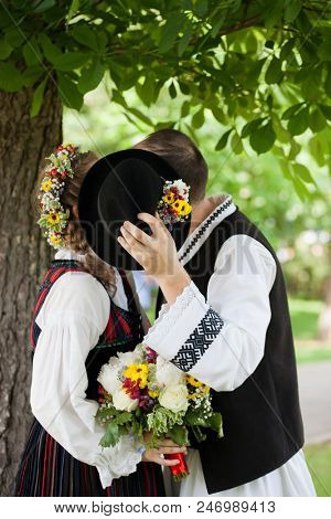 bride wearing a traditional hungarian wedding dress and groom in a traditional romanian costume - intereethnic marriage