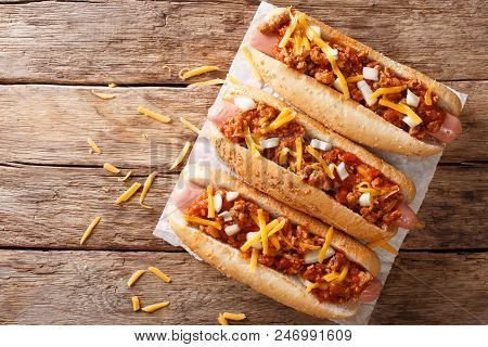 Traditional American Chili Hot Dogs With Cheddar Cheese, Onion And Spicy Sauce Closeup. Horizontal T