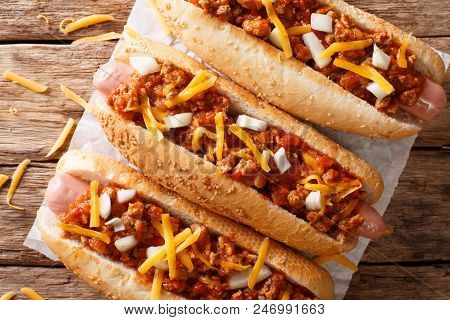 Chili Hot Dog With Cheddar Cheese And Spicy Sauce Close-up. Horizontal Top View From Above