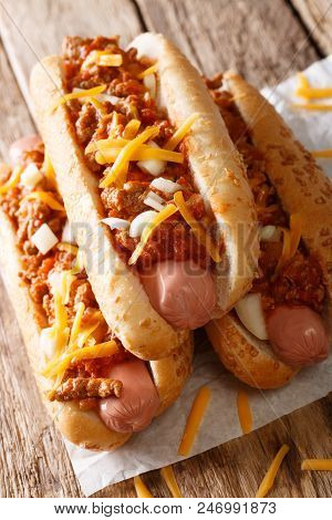 Chili Hot Dogs With Cheese Cheddar, Spicy Ground Beef, Onion And Sauce Close-up. Vertical