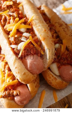 Chili Hot Dog With Cheddar Cheese And Spicy Sauce Close-up. Vertical