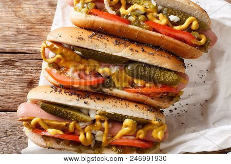 Homemade Chicago Style Hot Dogs With Mustard, Tomatoes, Pickled Cucumbers, Onions And Relish Close-u