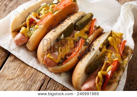 Homemade Chicago Style Hot Dogs With Mustard, Tomatoes, Pickled Cucumbers, Onions And Relish Close-u