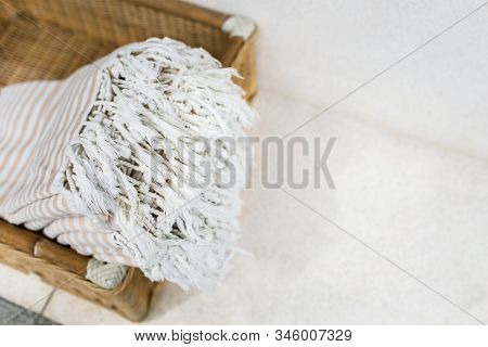 White Stripe Cotton Bath Towels Lying In Whicker Basket On White Background. Organic Pestemal Towels