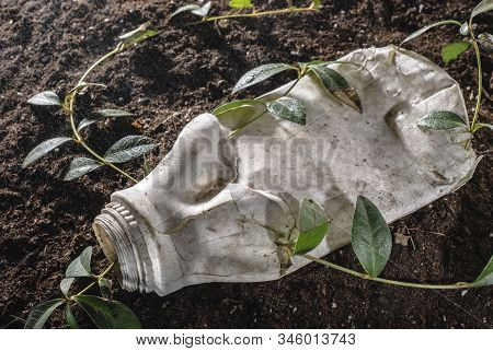 The Problem Of Mankind Is Environmental Pollution With Plastic. An Angry Flower Fights Breaking Thro