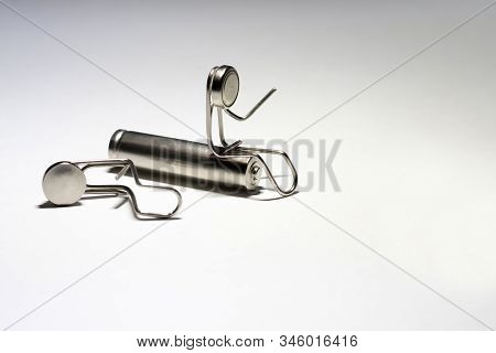 A Man Made Of Paper Clips Sits On A Cylindrical Battery. Next To It Is Another Man From The Paper Cl