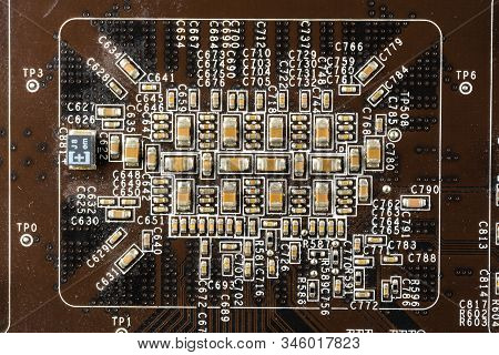 Black Computer Video Card Board With Brown Microcircuits And Various Electronic Components, Top View