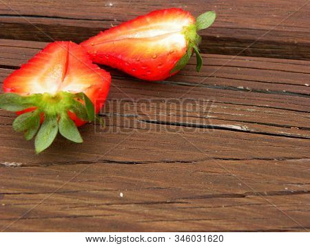 Halves Of Fresh Strawberries On A Wooden Table