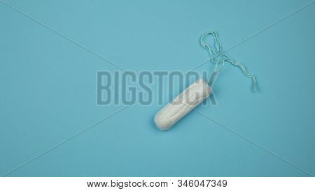 Medical Female Tampon On A Blue Background. Hygienic White Tampon For Women. Cotton Swab. Menstruati