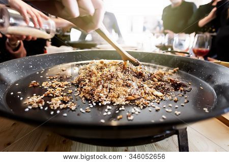 Paella Pan With Traditional Spanish Food Usually Prepared With Rice, Meat, Seafood. Mixing Process