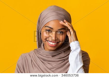 Closeup Portrait Of Smiling Afro Muslim Girl In Headscarf Shyly Looking At Camera And Touching Her T