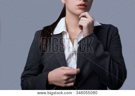 Portrait Of A Lovely Young Business Lady In A Business Suit. Girl Succinctly Holds Her Hands To Her 