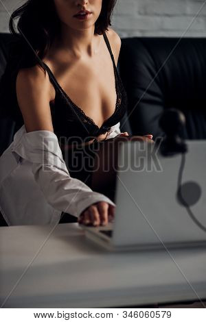 Cropped View Of Sexy Young Woman In Bra And Shirt Using Laptop With Web Camera On Sofa