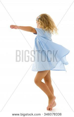 Beautiful Little Girl In A Dress Is Spinning. Concept Of Happy Childhood, Dancing, Holidays. Isolate