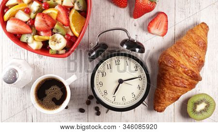 alarm clock with fruit, coffee and croissant