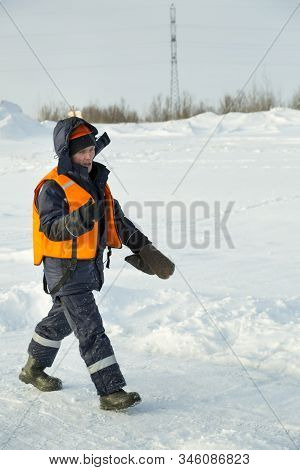 Slinger In An Orange Vest Walks On The Installation Site
