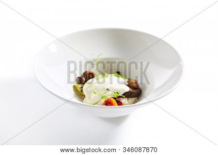 Risotto with grilled vegetables, carnaroli rice and cheese foam on white restaurant plate isolated. Traditional Italy rissoto or vegetable paella with cooked eggplants, mushrooms and greens closeup