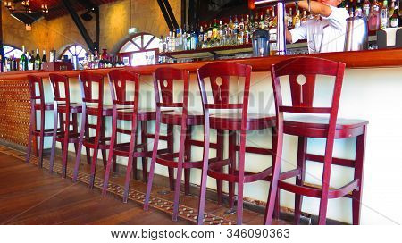 Hong Kong, Asia - November 13, 2019: Row Of Wooden Bar Stools In Empty Restauant In Victoria Peak Re