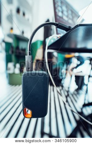 Powerbank Battery In Gray Color Charging Devise Through Black Usb Cable On Table